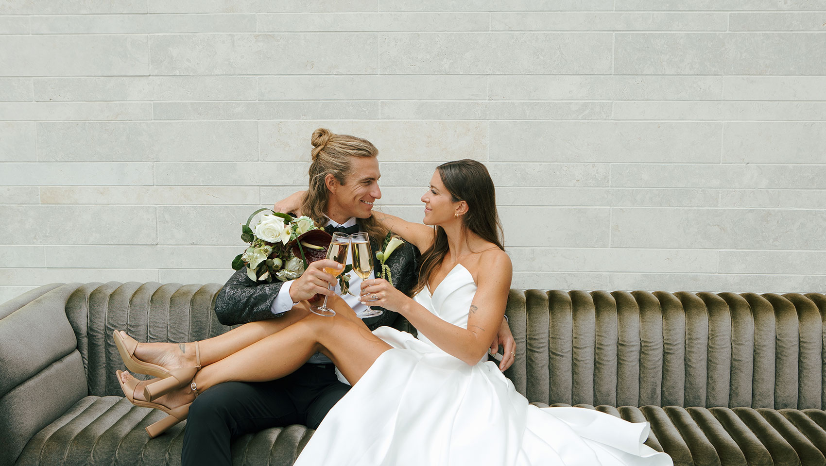 Bride & Groom on velvet couch at Kimpton Claret Hotel
